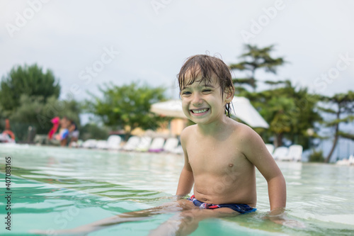 Young boy kid child splashing in swimming pool having fun leisure activity © Jasmin Merdan
