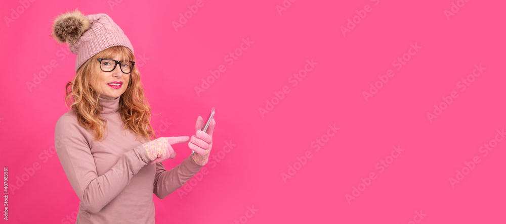 attractive adult woman with mobile phone isolated wearing warm clothes