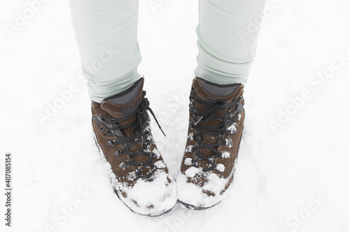 Female winter shoes covered with snow. Nice outdoor walk in a frosty park.