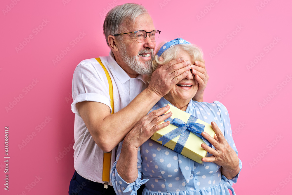mature man prepared surprise to wife, closes her eyes, woman stand holding gift box in hands, happy mature man prepared surprise to wife, closes her eyes, woman stand holding gift box in hands, happy