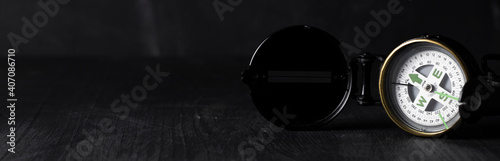 panorama banner with antique compass with lid on the right with space for text on the left on black background