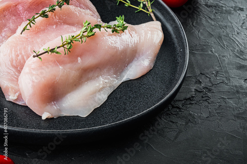 Raw fillet of chicken, on black background with copy space for text