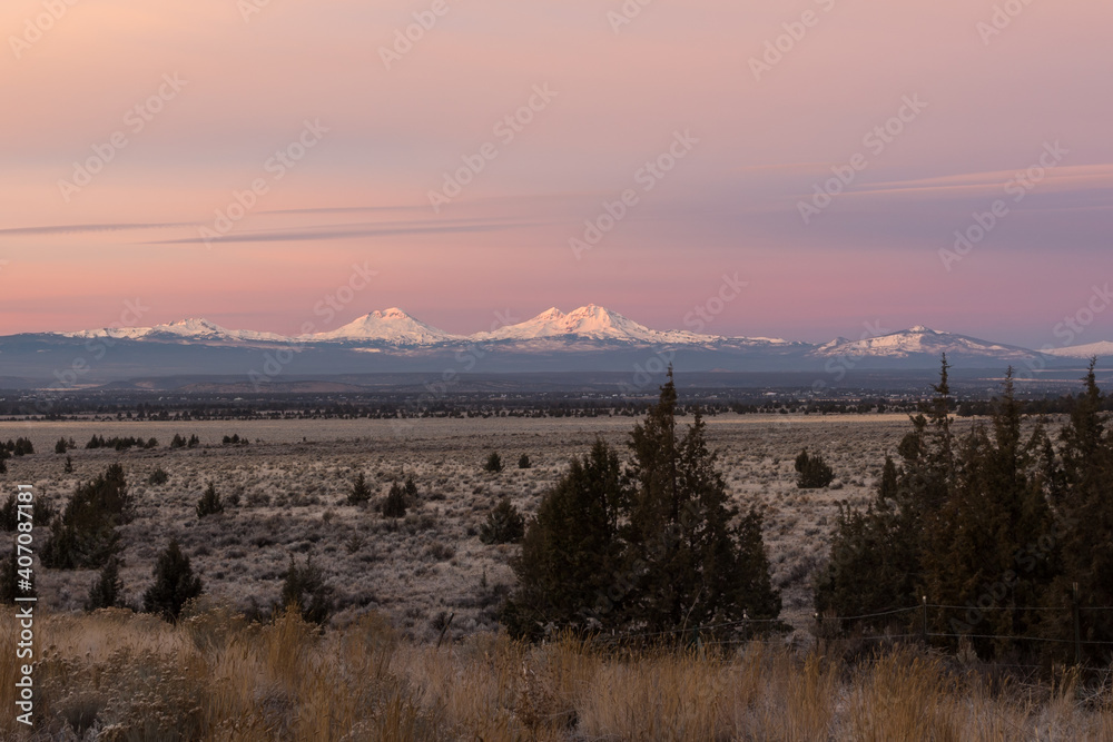 High desert landscape in early morning. Thee Sisters mountains on background. Central Oregon