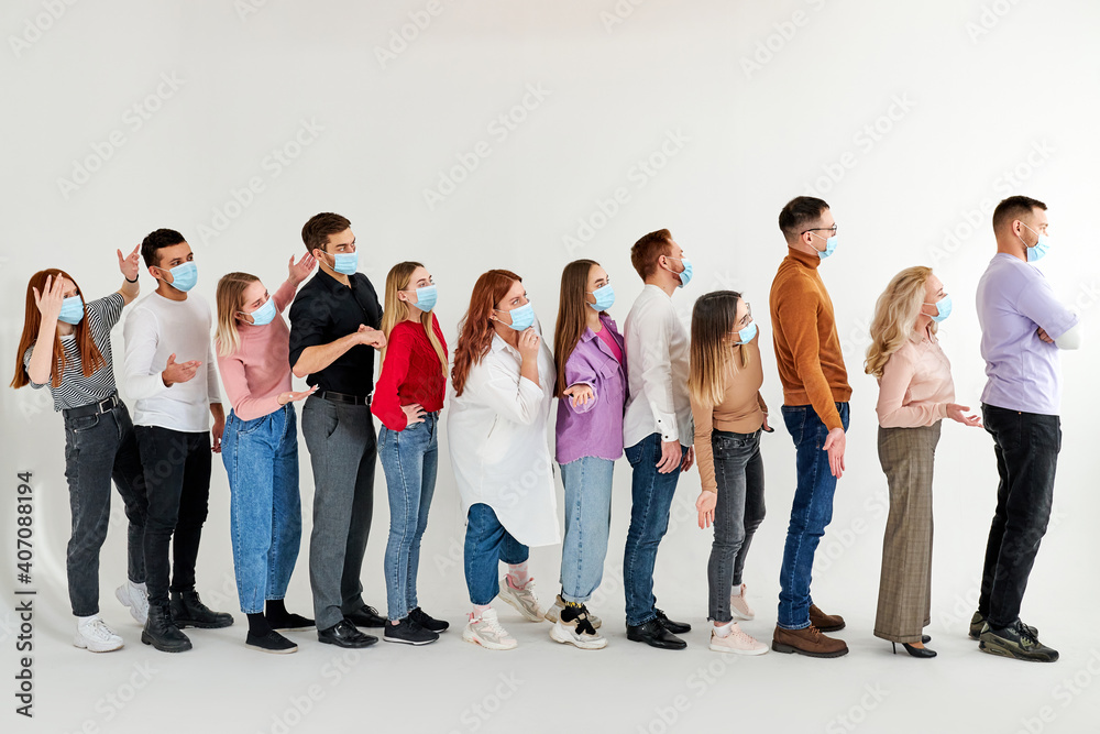 Obraz premium young diverse people stand in a row, in queue waiting for medical help, wearing medical masks on face. isolated over white background