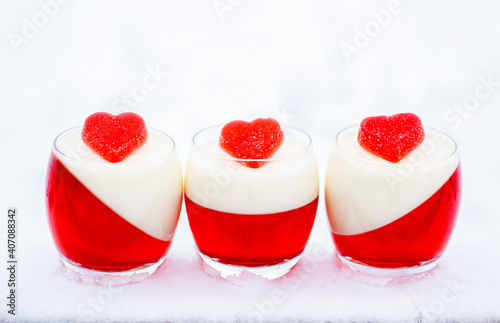 panna cotta with red jelly candies in shape of hearts in snow