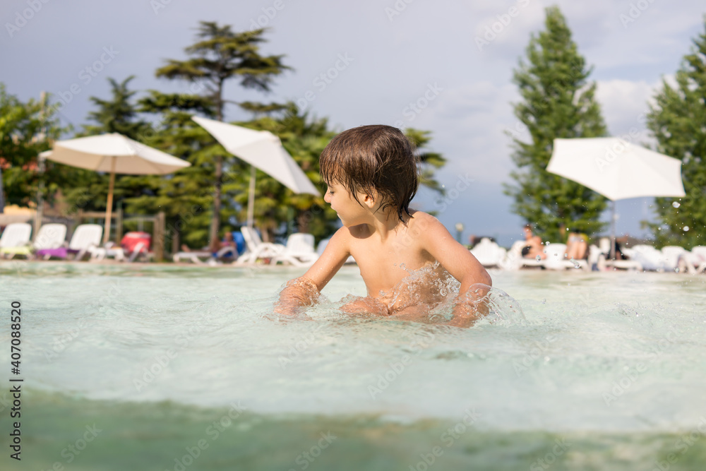 Cute little boy kid child splashing in swimming pool having fun leisure activity Cute little boy kid child splashing in swimming pool having fun leisure activity