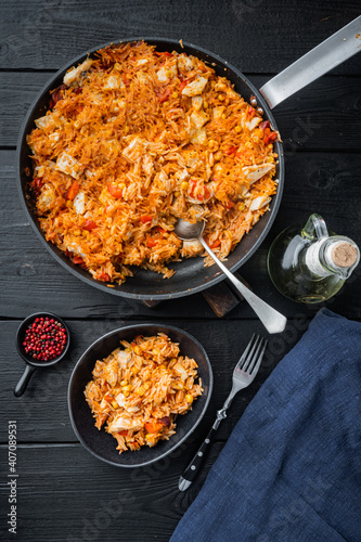 Chicken Enchiladas Served In Casserole, on black wooden table background, top view flat lay