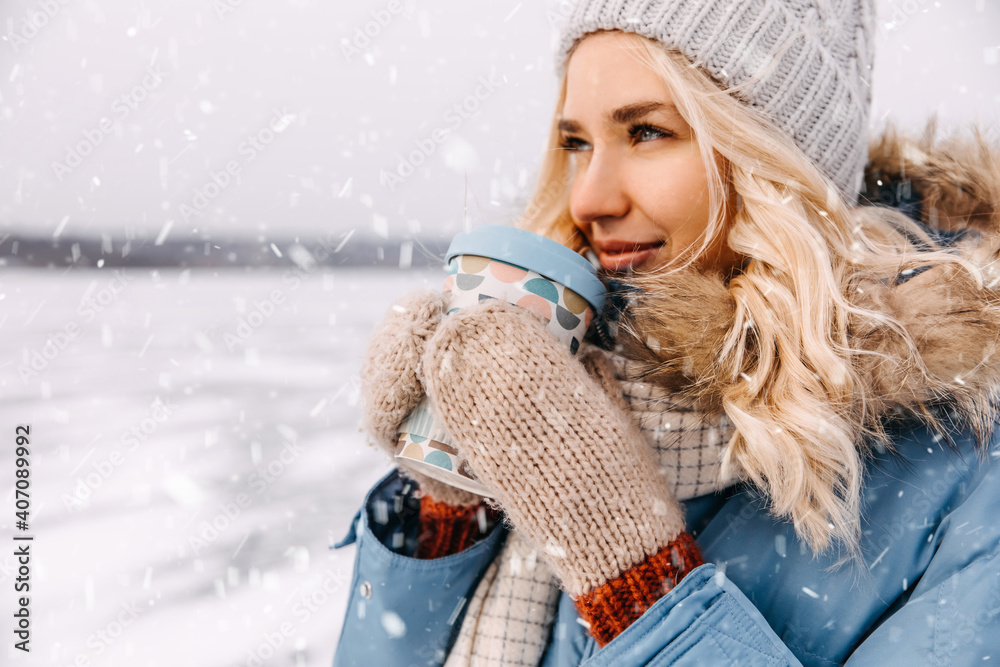 Closeup portrait of a young blonde woman with a cup of coffee on winter day, outdoors. Closeup portrait of a young blonde woman with a cup of coffee on winter day, outdoors.