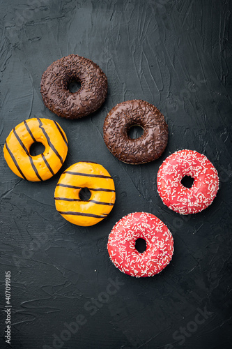 Glazed donuts, on black background, top view flat lay