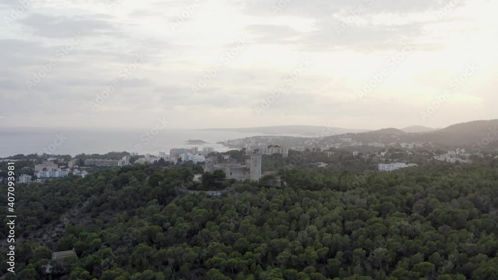 Landscape of mountains with a fortress on top of dron 4K video. Aerial view of mountain ranges with old historic fortress and city by the sea over background in Palma Spain. Landscape of mountains with a fortress on top of dron 4K video. Aerial view of mountain ranges with old historic fortress and city by the sea over background in Palma Spain.