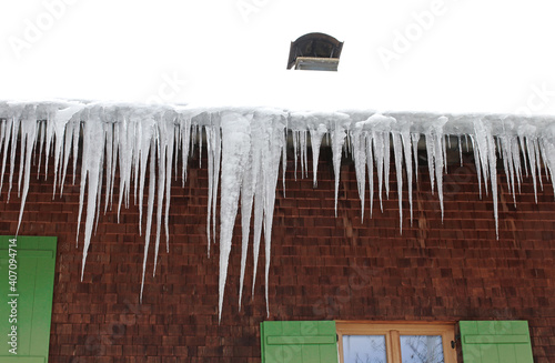 Viele große gefährliche Eiszapfen an Hausdächern im Winter photo