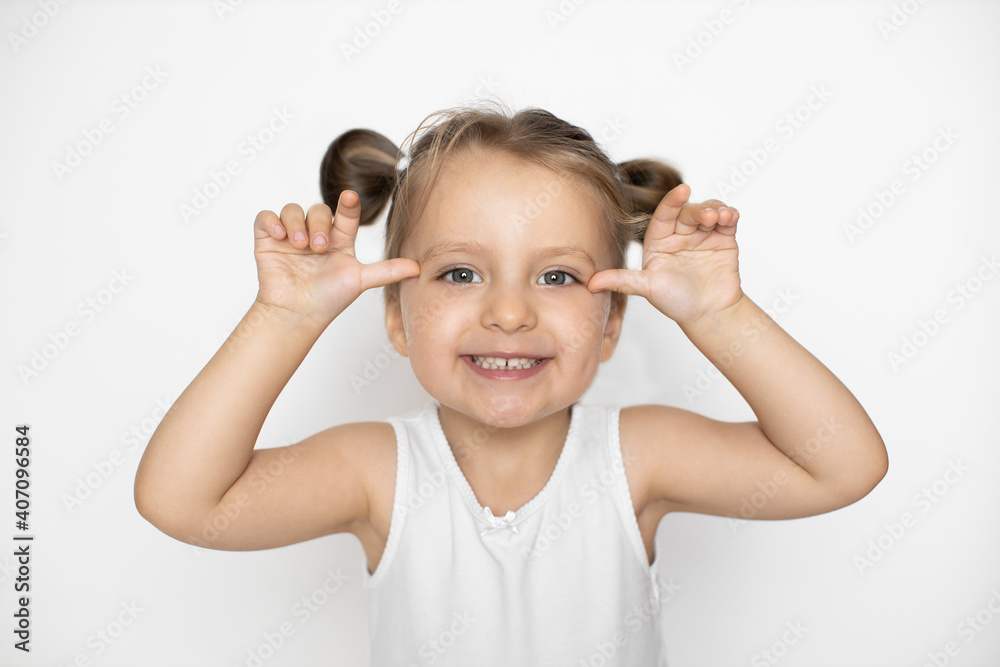 Little cute laughing Caucasian 3 years old girl makes grimace with her hands and face. Crazy funny little girl grimacing, isolated on white background Little cute laughing Caucasian 3 years old girl makes grimace with her hands and face. Crazy funny little girl grimacing, isolated on white background
