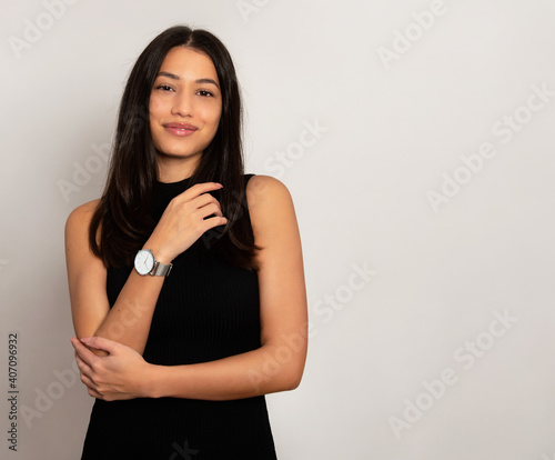 Beautiful young woman with long black hair wearing wirst watch  Youthful and radian girl with natural make-up