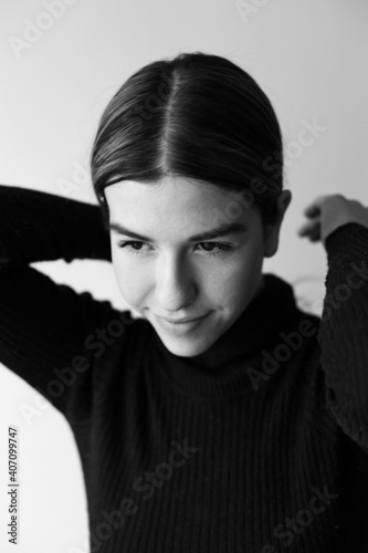 Black and white portrait of a young woman. she is wearing a black sweater