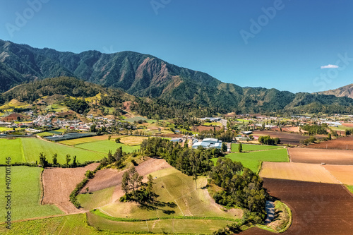 Aerial view of large mountains and agriculture under a clear sky in the constanza valley, la vega, Dominican Republic photo
