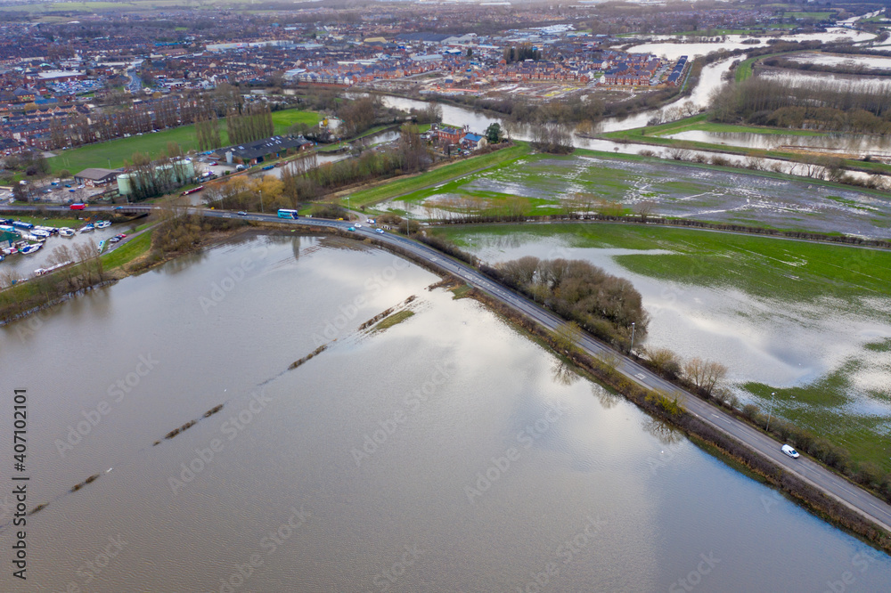 Fototapeta premium Aerial drone photo of the town of Allerton Bywater near Castleford in Leeds West Yorkshire showing the flooded fields from the River Aire on a rainy winters day during a large flood after a storm.