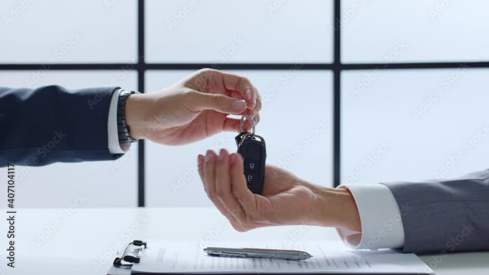 Closeup hand giving a car key and money for loan credit financial, lease and rental concept