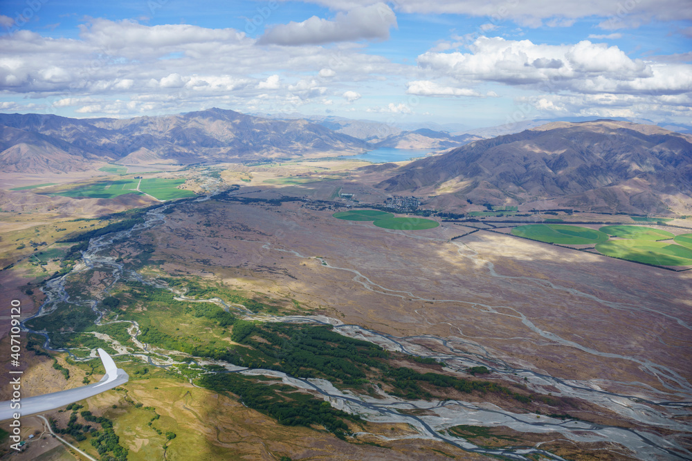 Aerial view of  braided river Canterbury landscape through perspex canopy from within glider cockpit in flight.