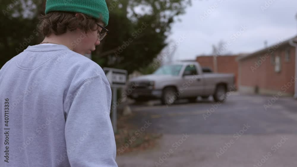 Teenage boy with skateboard walks towards an alley in slow motion. Teenage boy with skateboard walks towards an alley in slow motion.