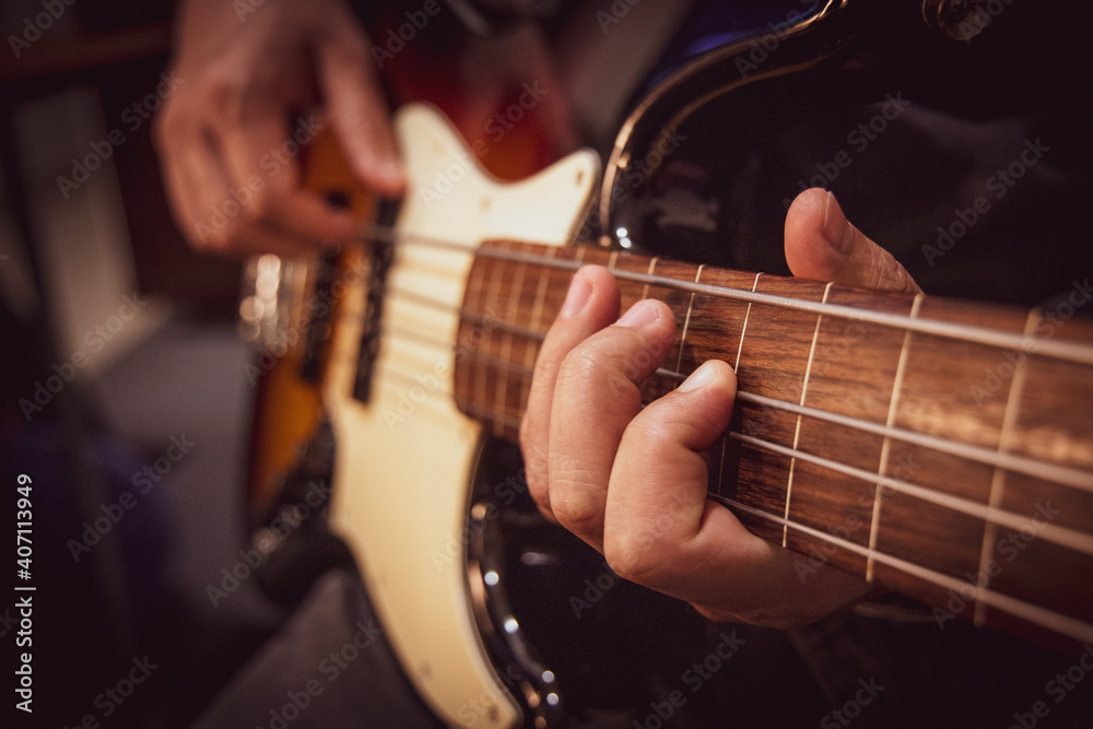 Fototapeta premium Male hands playing fretless bass guitar