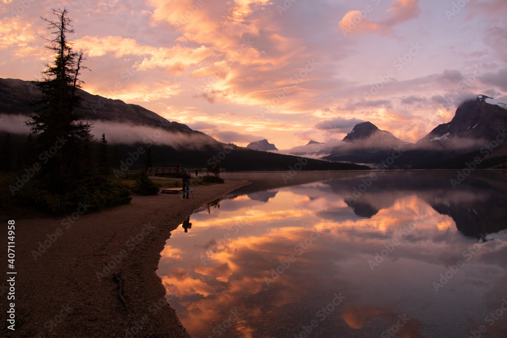 Scenic landscape view of Bow Lake taken at sunrise with colourful reflections in the lake.