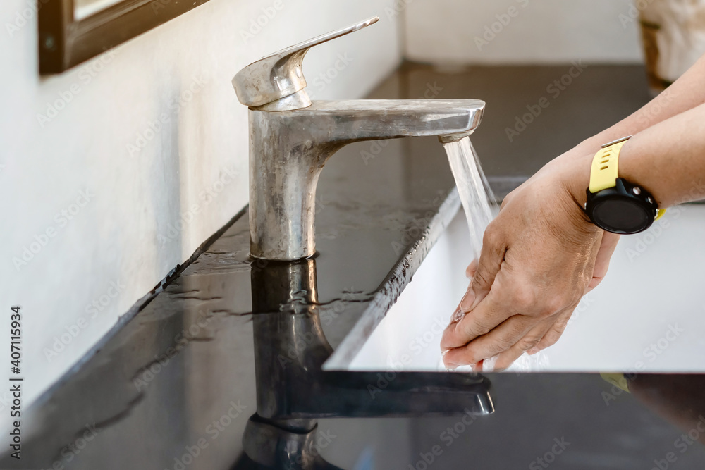 Senior woman use soap and washing hands under the water tap. COVID-19 ...