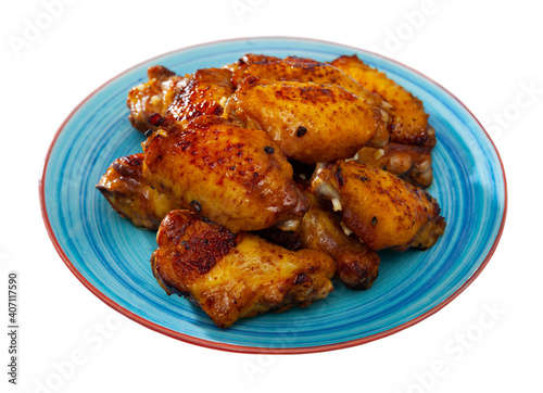 Delicious fried chicken wings with golden crust served with on plate. Isolated over white background
