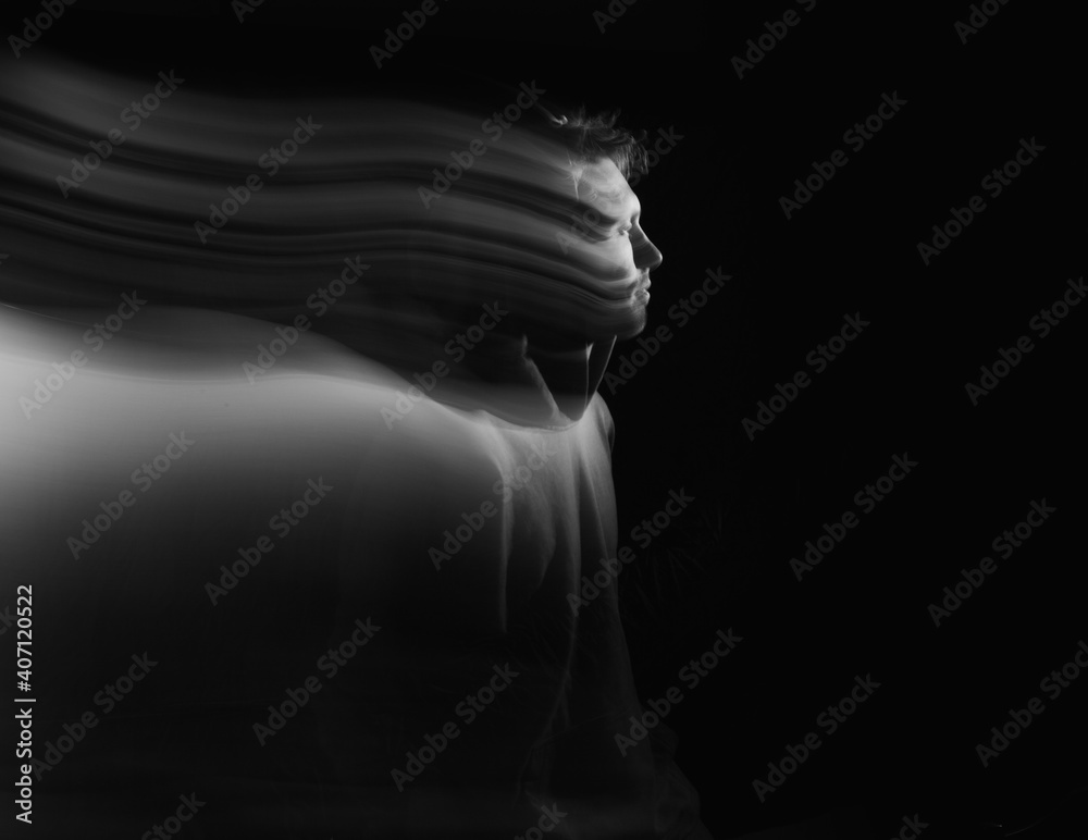 Obraz premium Facial face of a man in the dark. Art photography. Black-white art picture with a man. Portrait of man with blurred motion