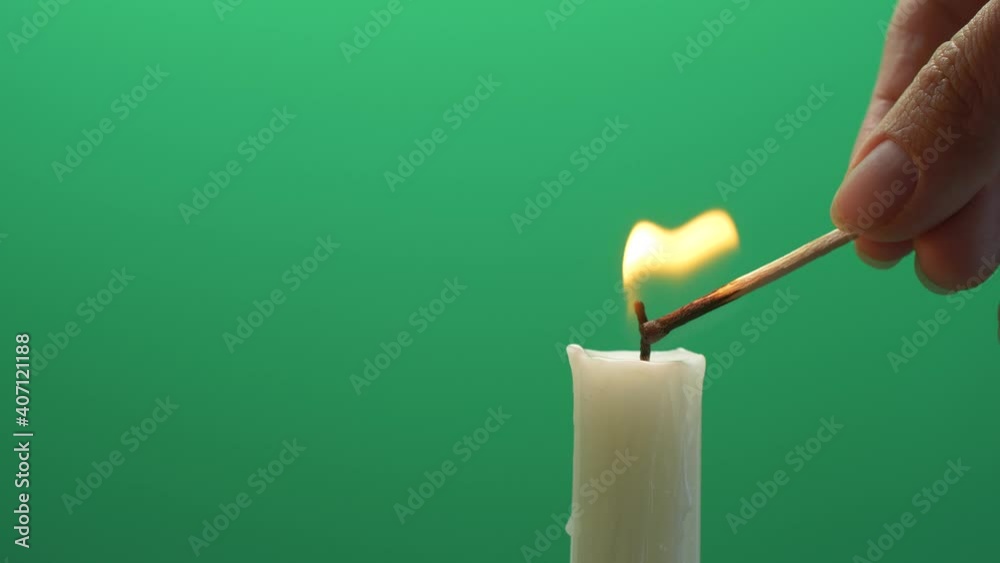 Closeup candle flame igniting and burning on chroma key green screen background