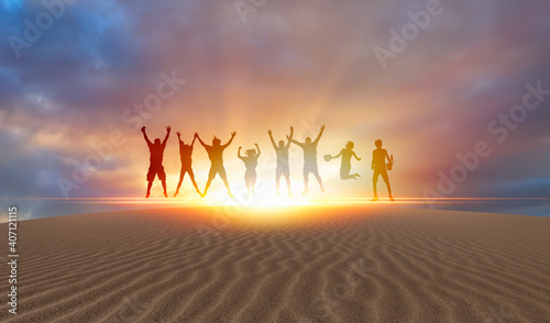 Silhouette of friends jumping at Sunset   Sand dune with Desert in the foreground in the foreground