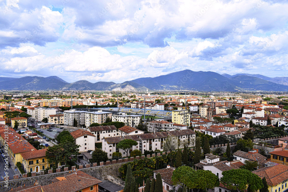 view of the surrounding city and mountain range from the pisa tower
