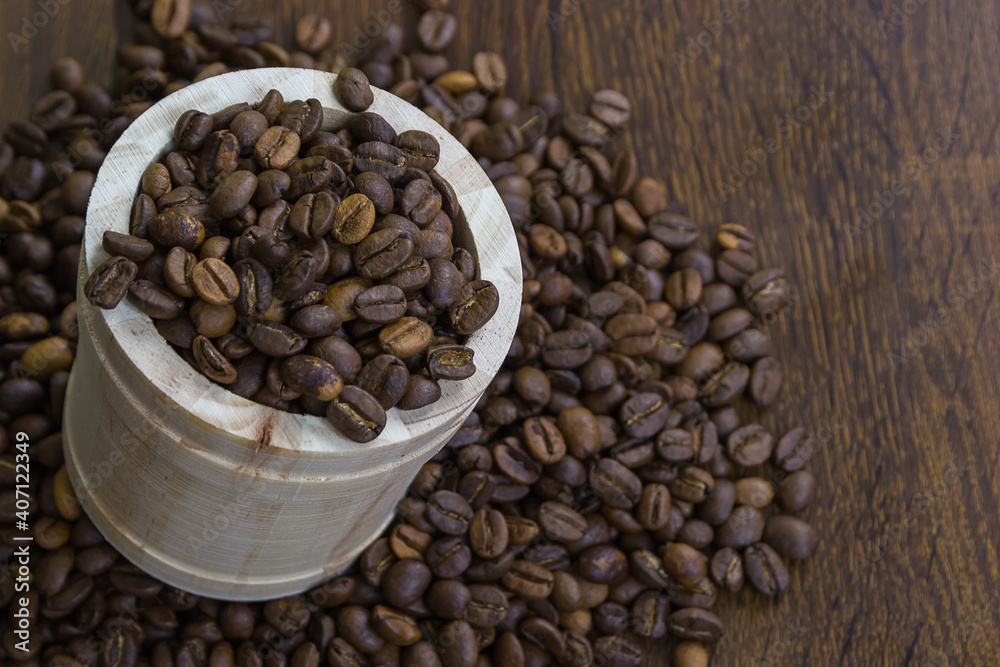 Fototapeta premium Coffee beans in small wooden bucket with coffee beans on table