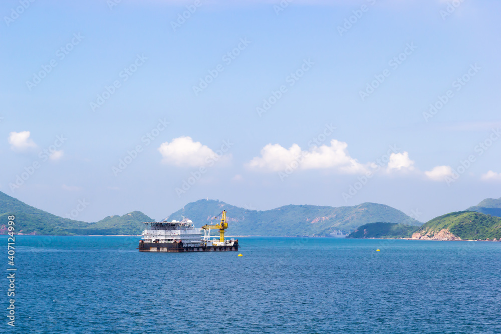 Ship for marine industry floating on sea and see mountains and sky background