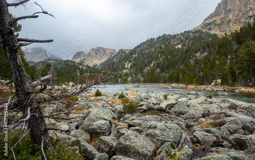 Autumn landscape of Ratera de Colomers lake, glacial origin lake surrounded by Spanish Pyrenees in Aiguestortes National Park, Pallars Sobira, Catalonia, Spain photo