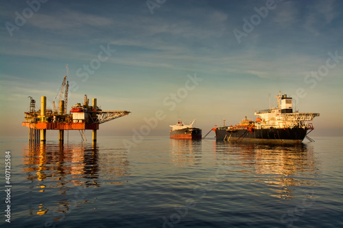 oil filed view with jack up oil rig and crude oil tanker