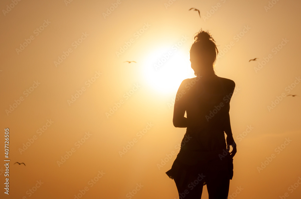 Silhouette young woman enjoying on the beach