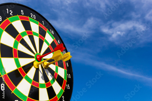 Dart magnet on center board blue sky background for use to business goal