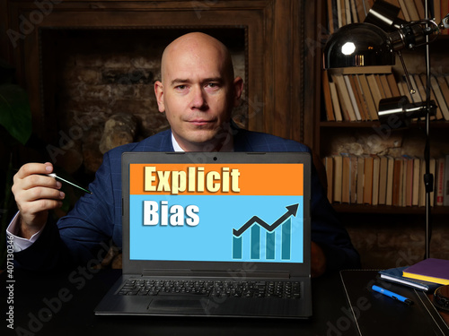 Businessman holding a laptop. Business concept about Explicit Bias with phrase on the sheet.