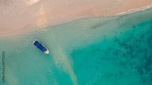 aerial top view of boat parking on clear blue sea beach