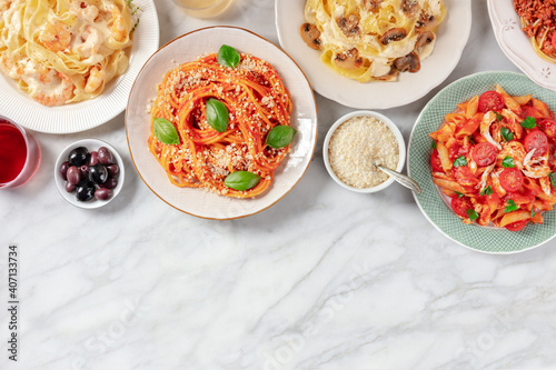 Pasta assortment  shot from above with a place for text  a flat lay on a white marble background