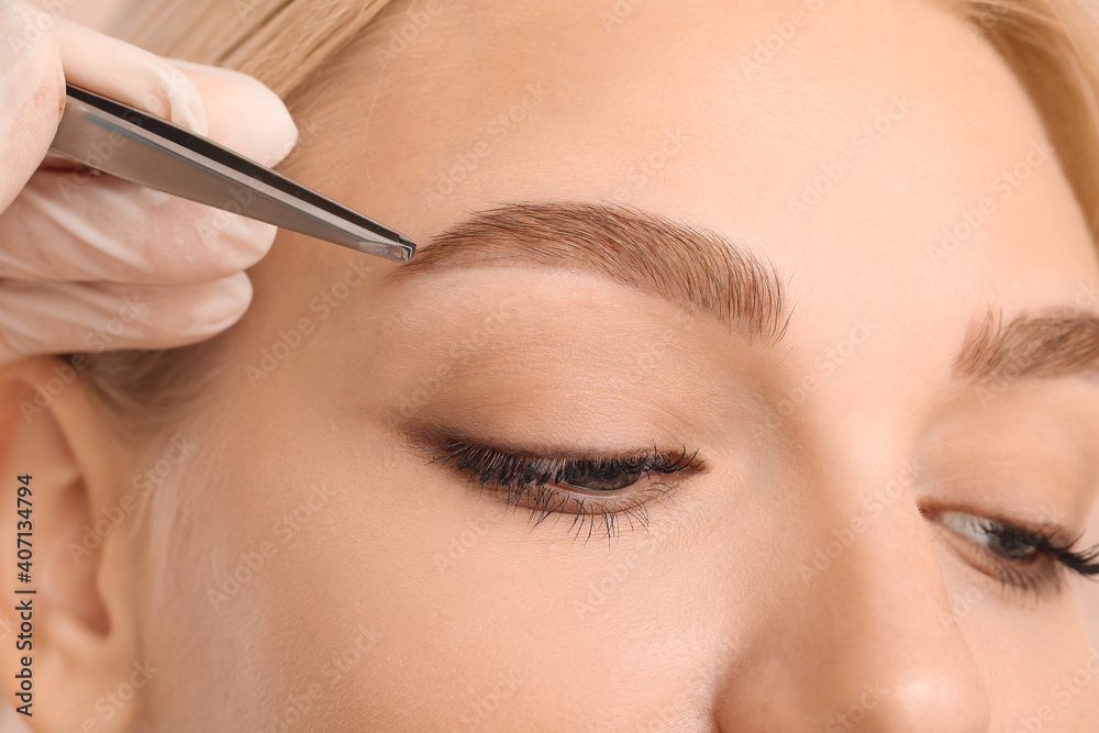 Young woman undergoing eyebrow correction procedure, closeup