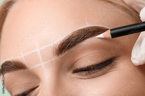 Photo Young woman undergoing eyebrow correction procedure, closeup