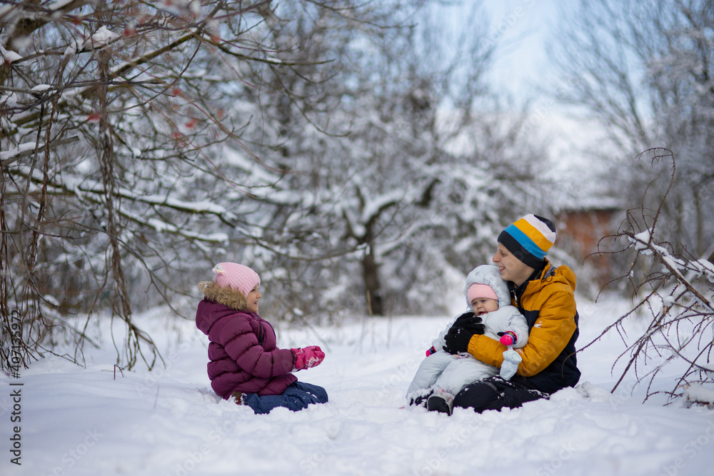 Three children on a walk in winter, a teenager
