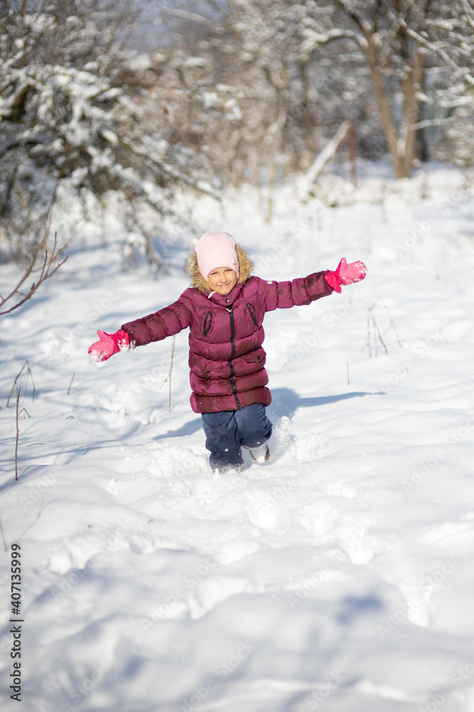 A child girl on a walk in a winter park