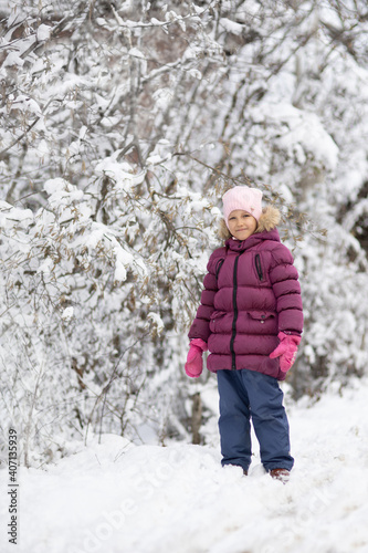A child girl on a walk in a winter park