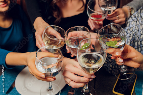 Clinking glasses with alcohol and toasting, party.