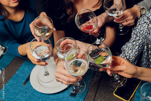 Clinking glasses with alcohol and toasting, party.