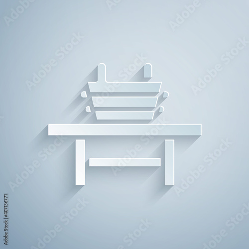 Paper cut Sauna bench with bucket icon isolated on grey background. Paper art style. Vector.