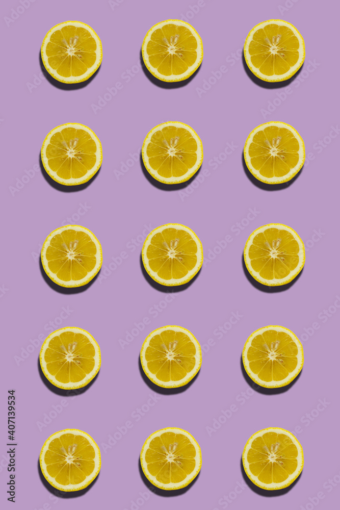 Slices of lemon with shadow on summer pattern evenly colored background.
