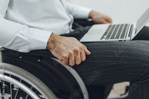 Disabled man in a wheelchair using laptop
